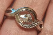 A 925 sterling silver ring with a floating diamond centerpiece.