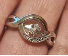 A 925 sterling silver ring with a floating diamond centerpiece.
