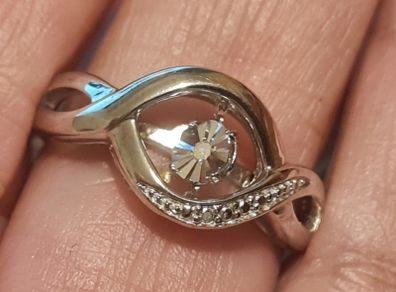 A 925 sterling silver ring with a floating diamond centerpiece.