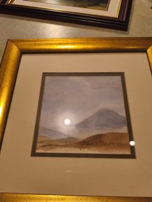 Gold framed picruer of land scape.