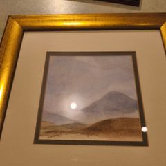 Gold framed picruer of land scape.