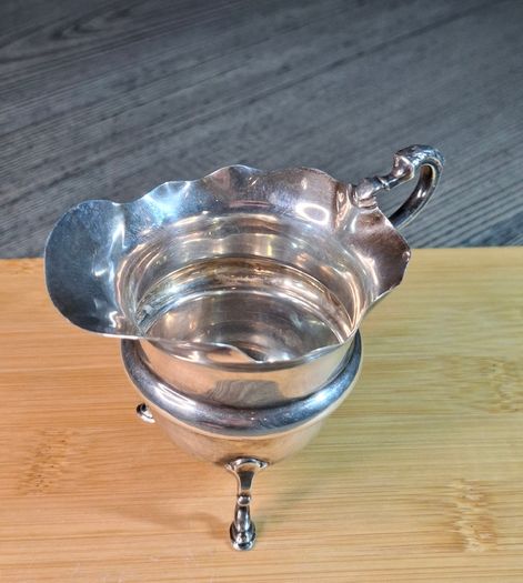 Antique silver cream jug with scalloped rim
