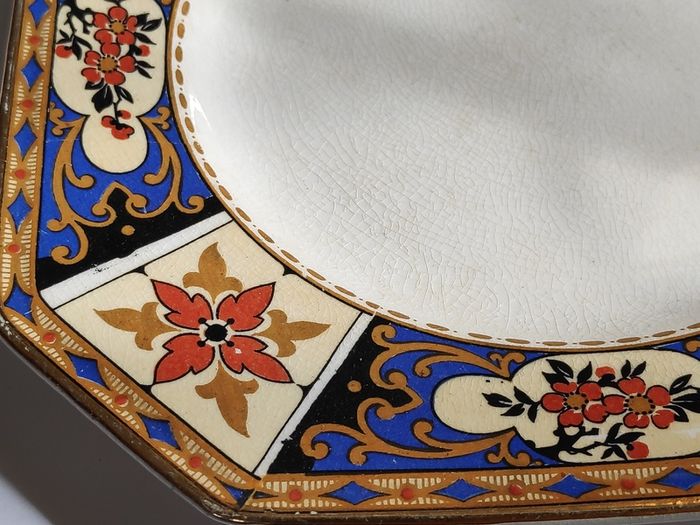 Antique small octagonal plate with floral pattern in blue, red and ochre tones