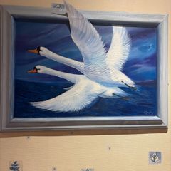 A commissioned painting of two swans with the wing of one swan overlapping the frame