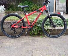 Rockrider ST 900. 24in wheels, mechanical disc brakes, front suspension forks, 8 gears. In good working order with the usual scrapes and scratches from kid use.