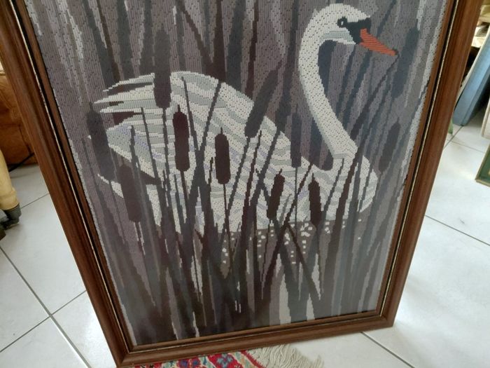 Vintage framed needlepoint tapestry depicting a white swan swimming