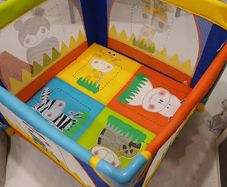 Bright and colorful square baby playpen featuring a cheerful animal safari theme.