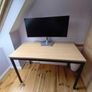 Modern desk with light wood top and black metal frame Image 3