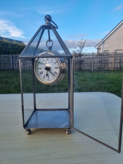 Table clock in a glass lantern.