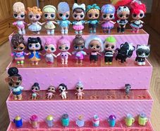 A lot of L.O.L. Surprise dolls with accessories and a doll podium.