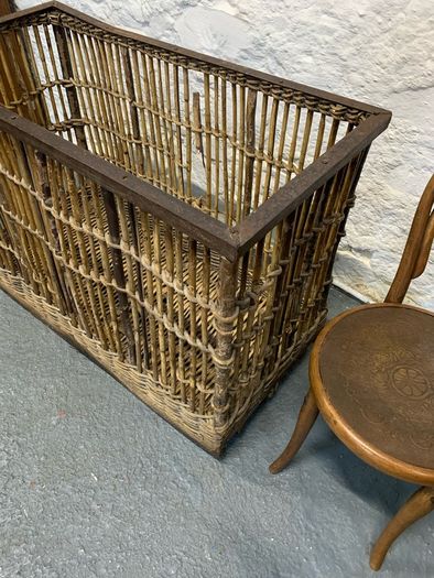 Large Victorian cane and metal laundry basket on wheels.