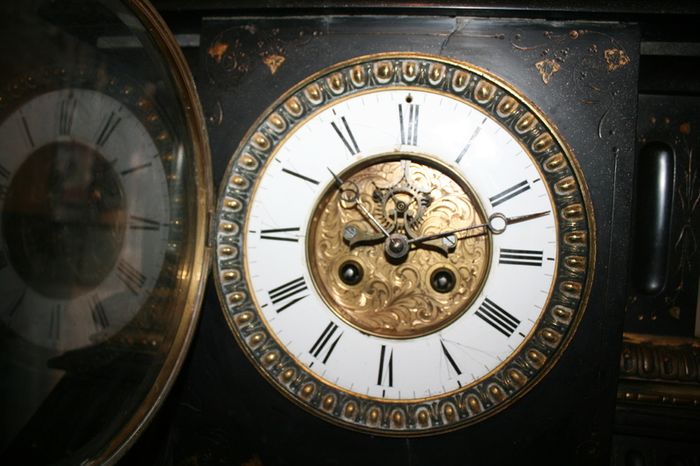 Victorian French Black Slate Mantle Clock (Very large and heavy) with bronze ornamentation Oversized. Open escarpment slate plate Roman numerals. Circa 1890s. Accented with Trojan head. Flanked by two Hellenistic ladies heads on sides. Rose cartouche mask