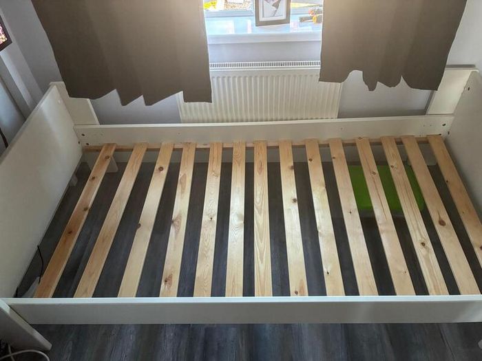 White single bed frame with wooden slats