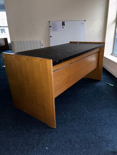 Large wooden reception desk with black countertop