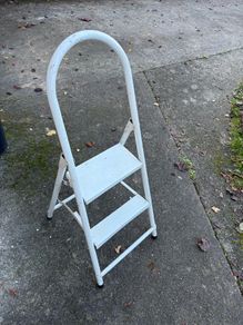 white metal 2-step folding household ladder with a high safety handrail.