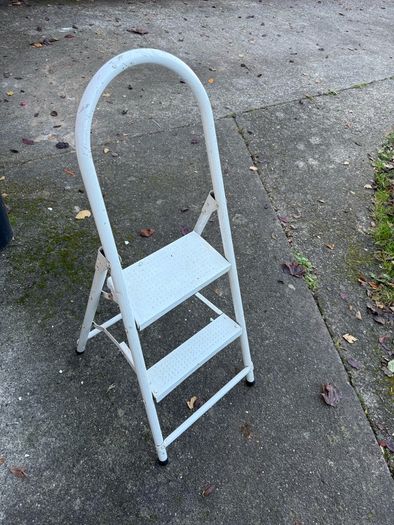 white metal 2-step folding household ladder with a high safety handrail.