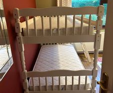 White wooden bunk beds with mattresses
