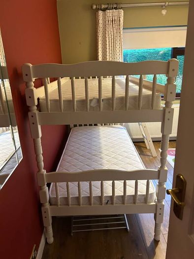 White wooden bunk beds with mattresses