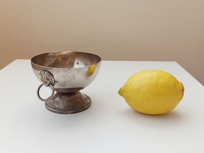 Small silver plated bowl with handles cast as lion's head holding a ring