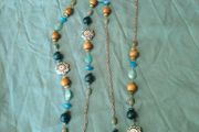 long, colorful beaded necklace featuring a mix of wood, blue, and white floral beads.