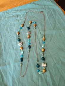 long, colorful beaded necklace featuring a mix of wood, blue, and white floral beads.