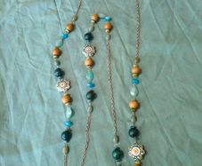 long, colorful beaded necklace featuring a mix of wood, blue, and white floral beads.