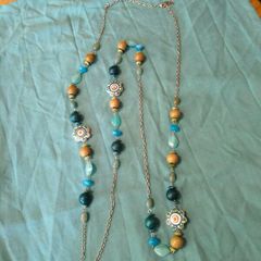 long, colorful beaded necklace featuring a mix of wood, blue, and white floral beads.