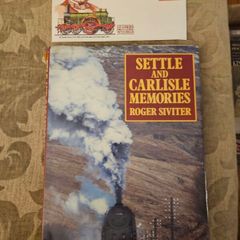 Settle And Carlisle Memories.  By Roger Siviter. 1990 First Edition Large Volume Hardback With Dustjacket In Good Condition.  Plus first day issue stamp.  See Photos For Same.