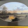 VINTAGE Framed landscape print featuring an oval matte aperture with a golden sunset or sunrise over a river, bare trees, and two birds flying in the sky. Image 3