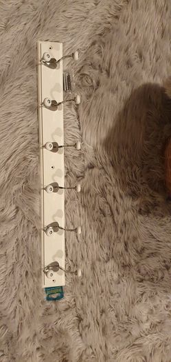 Coat and hats chrome hooks on white board.