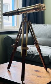 Large brass double barrel binocular telescope on wooden tripod