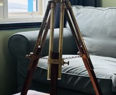 Large brass double barrel binocular telescope on wooden tripod