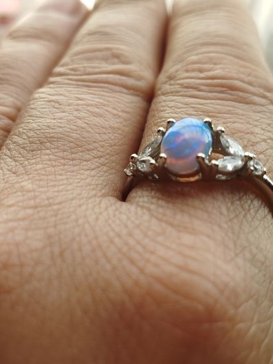 Ring made of 925 silver with oval opal of blue shade and cubic zirconia.