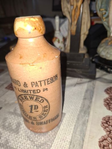 Antique stoneware ginger beer bottle from the Norfolk brewer Steward & Patteson Limited, featuring a "1D" (one penny) price mark