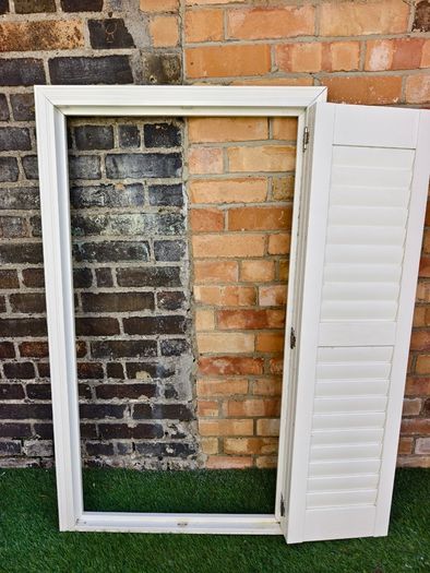 Vintage-style louvered white internal window shutter