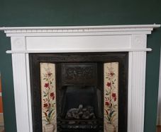 Fireplace in cast iron with wooden surround (painted white) and black marble hearth.   Perfect condition
