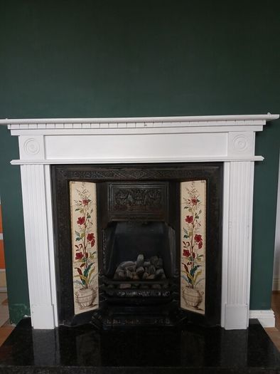 Fireplace in cast iron with wooden surround (painted white) and black marble hearth.   Perfect condition