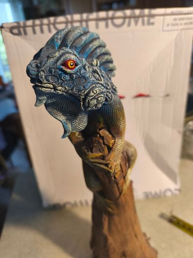 handmade iguana on natural wood log