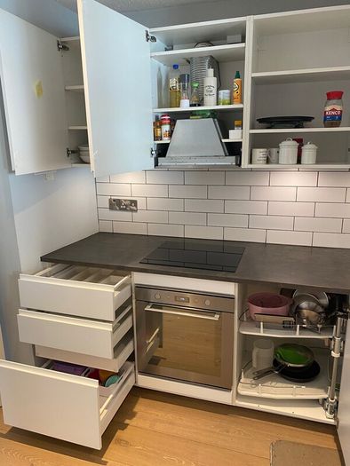 Modern white kitchen units and tall larder storage