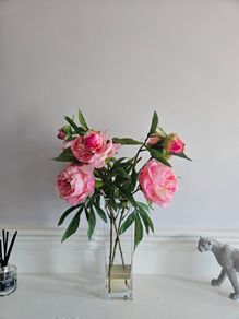 artificial pink flowers in a glass vase
