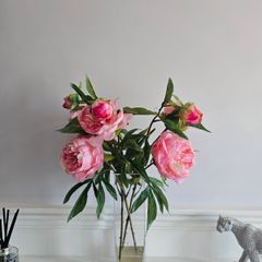artificial pink flowers in a glass vase
