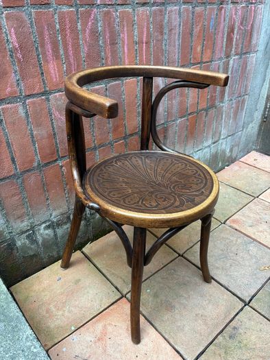 A vintage 1920s Thonet style bentwood chair with armrests.