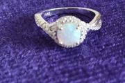 A beautiful 925 silver ring with a white lab opal surrounded by shining cubic zirconia.