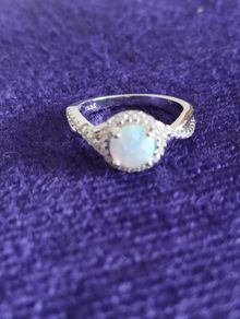 A beautiful 925 silver ring with a white lab opal surrounded by shining cubic zirconia.