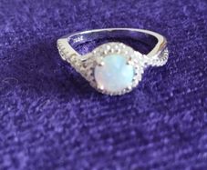 A beautiful 925 silver ring with a white lab opal surrounded by shining cubic zirconia.