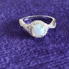 A beautiful 925 silver ring with a white lab opal surrounded by shining cubic zirconia.