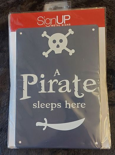 A pirate sleeps here metal sign