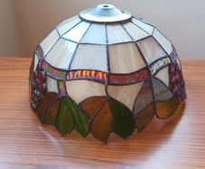 Vintage Tiffany-style stained glass lampshade featuring a bunch of red grapes set against a cream-colored background with green and brown leaves