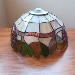 Vintage Tiffany-style stained glass lampshade featuring a bunch of red grapes set against a cream-colored background with green and brown leaves