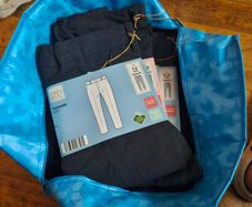 Bag of school pinafores and trousers.